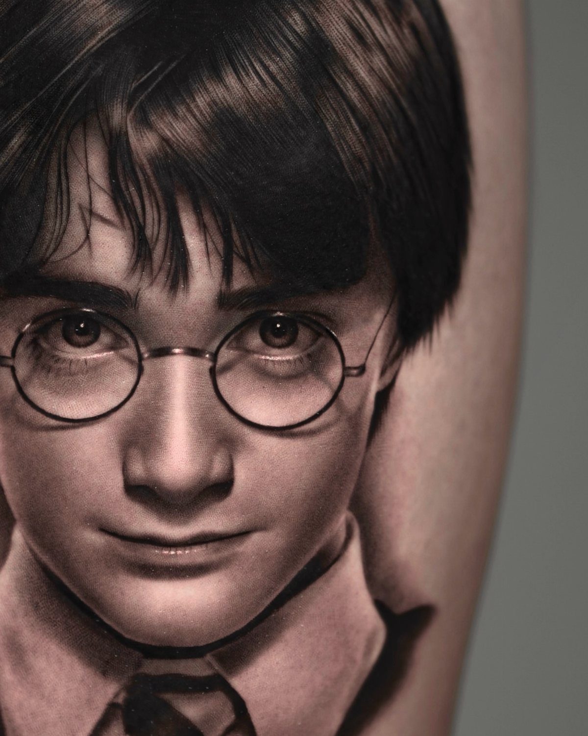 Harry Potter portrait tattoo with round glasses on a person's skin